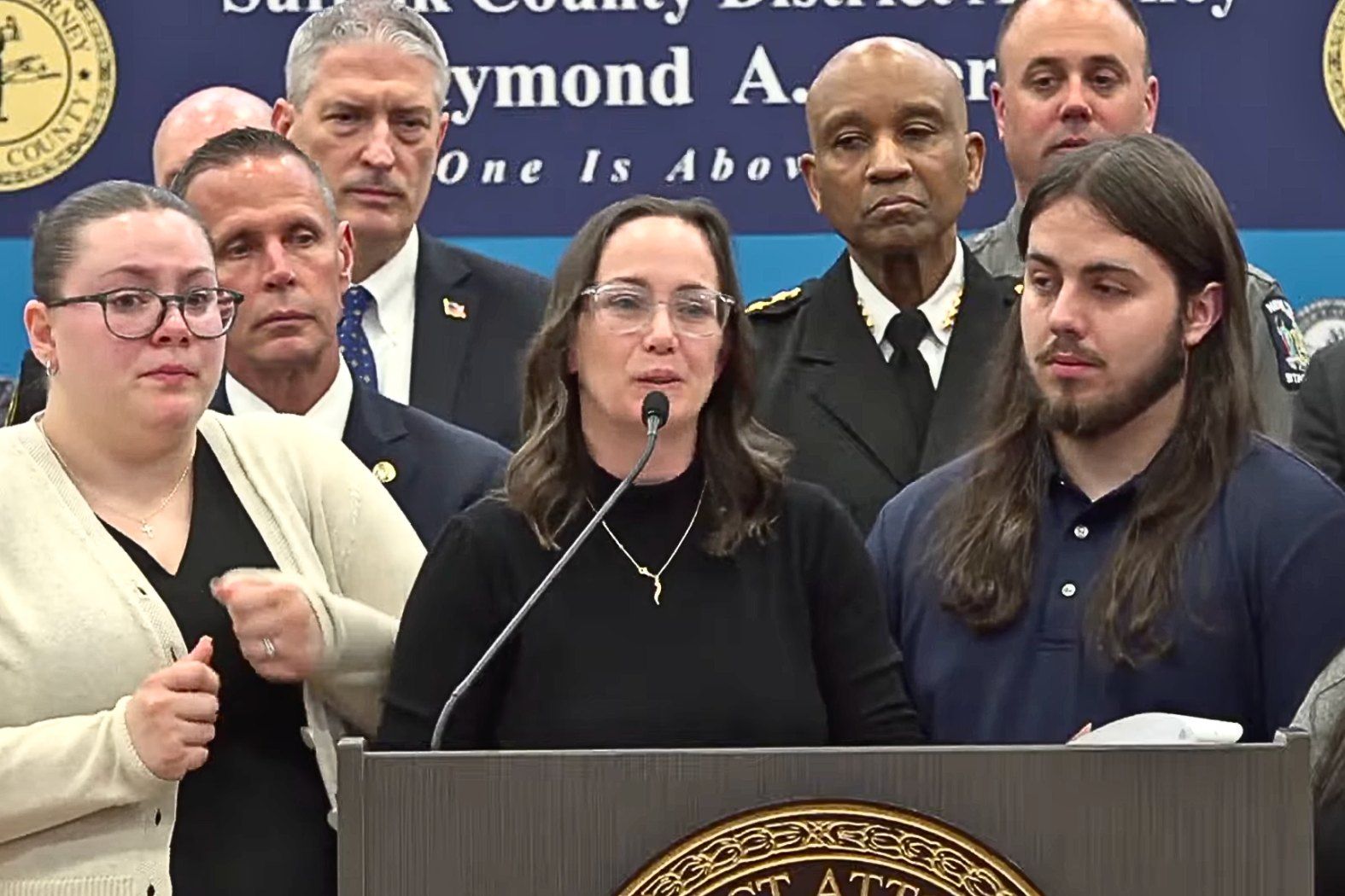 Melissa Caan speaks at podium during Heuermann guilty plea press conference.