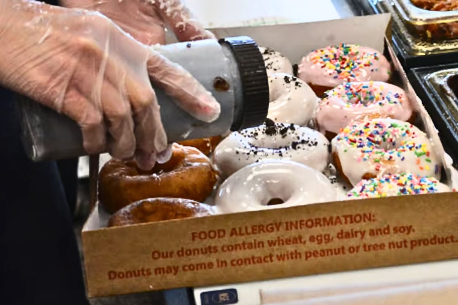 A worker puts the finishing touches on a box of Duck Donuts.